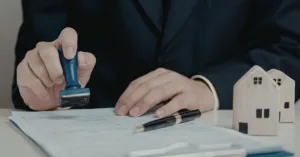 Pessoa carimbando documentos imobiliários para regularização de imóvel por usucapião extrajudicial no cartório