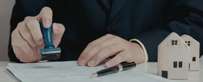 Pessoa carimbando documentos imobiliários para regularização de imóvel por usucapião extrajudicial no cartório