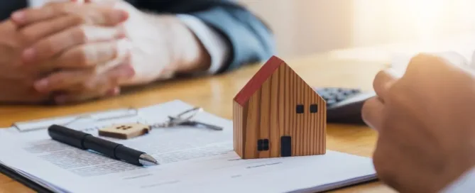 Contrato de compra de imóvel com casa em miniatura e chave representando sinal pago na negociação