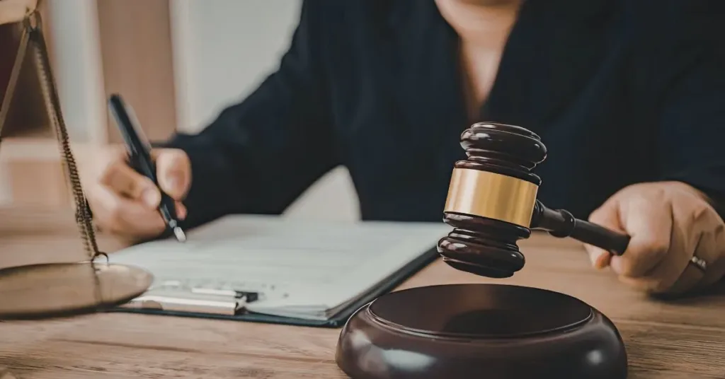Profissional do Direito analisando documentos sobre exoneração de alimentos ao lado de um martelo de juiz.