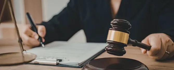 Profissional do Direito analisando documentos sobre exoneração de alimentos ao lado de um martelo de juiz.