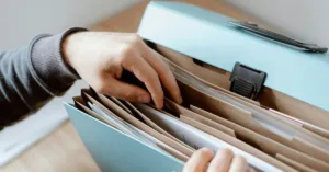 Pessoa procurando documentos para realizar a sobrepartilha de bens após o inventário encerrado.