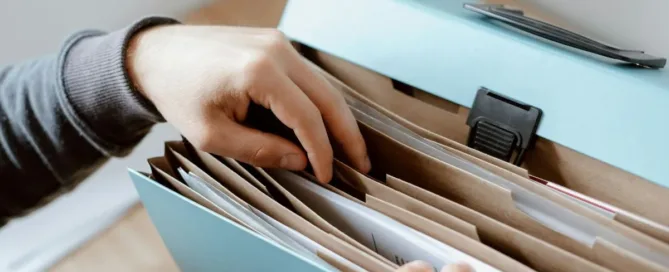 Pessoa procurando documentos para realizar a sobrepartilha de bens após o inventário encerrado.