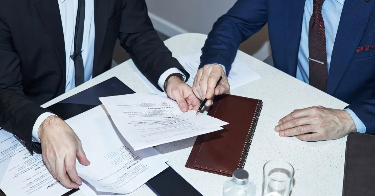 Dois empresários analisando documentos societários sobre uma mesa