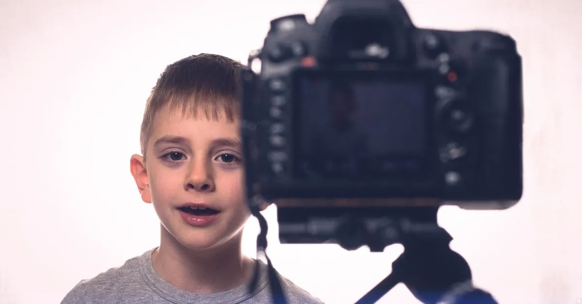 Criança influenciadora gravando conteúdo em frente a uma câmera, representando os limites da exposição infantil nas redes sociais.
