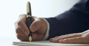 Pessoa assinando documento para formalizar distrato contratual e encerramento de contrato.